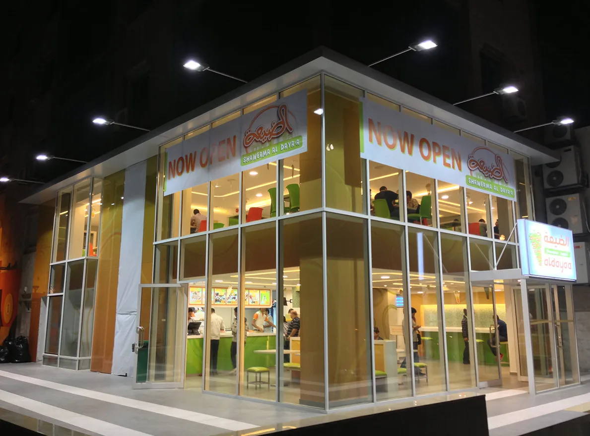 Al Dayaa Restaurant illuminated glazed corner building at night