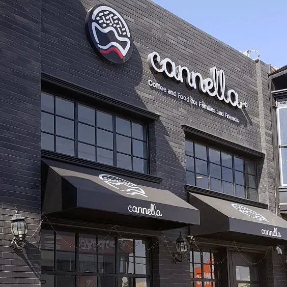 Cannella Café dark brick storefront with large windows and black entrance awnings